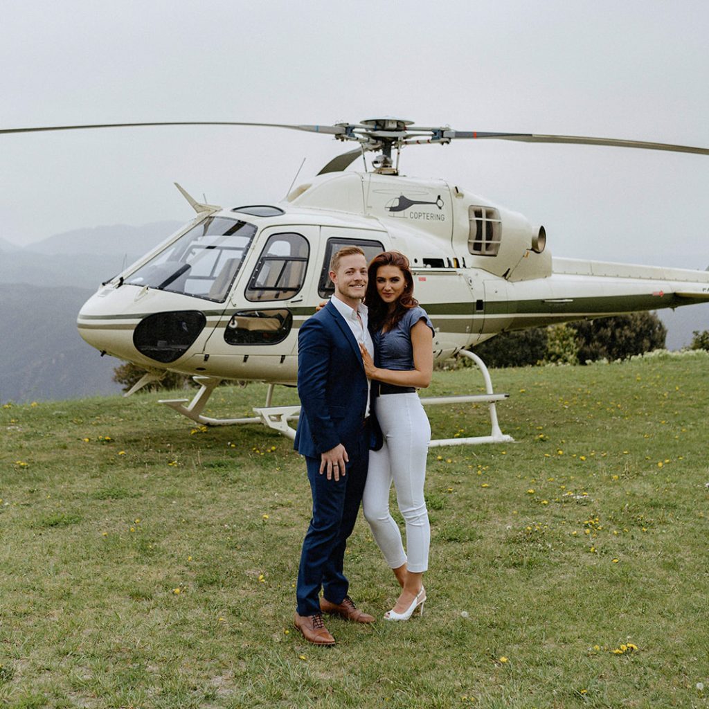 Couple is in front of helicopter